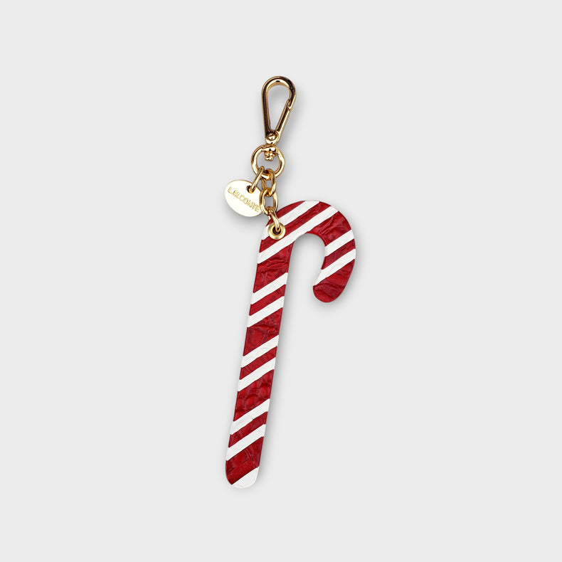Candy cane-shaped keychain with gold clasp against a soft gray background.