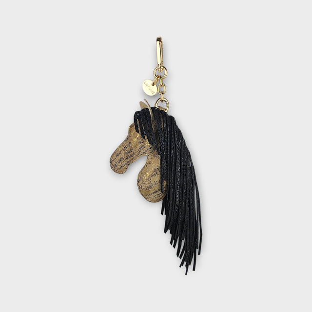 Bag charm of a horse design with black fringe as the mane on a light gray background.