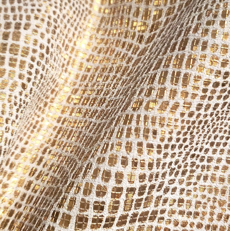 Close-up of a textured fabric with gold and beige pattern