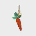 Carrot-shaped bag charm with green leaves at the top and orange body on a light gray background.