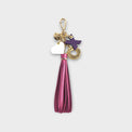 Keychain with pink fringe tassel and colorful X-O letter charms with a heart against a light gray background.