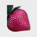 A zoomed imaged of a pink strawberry-shaped leather bag charm with ombré
 crystal stone embellishments. 